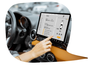 A woman's hand reaches forward to tap on the digital display in the center of her car's dashboard console.